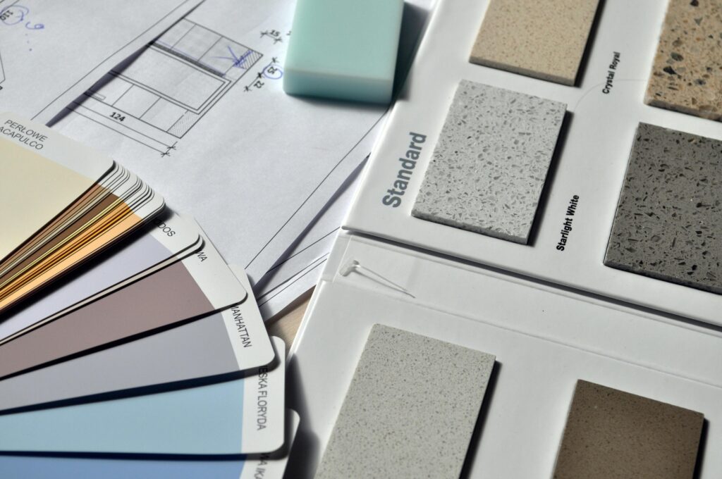 Color palette and material samples for interior renovation projects on a blueprint.